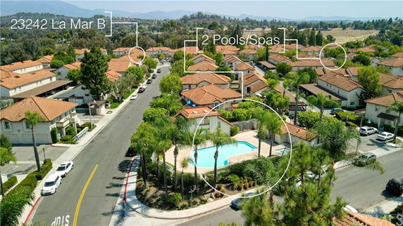 Panoramic view of a residential area with a pool and multiple houses.