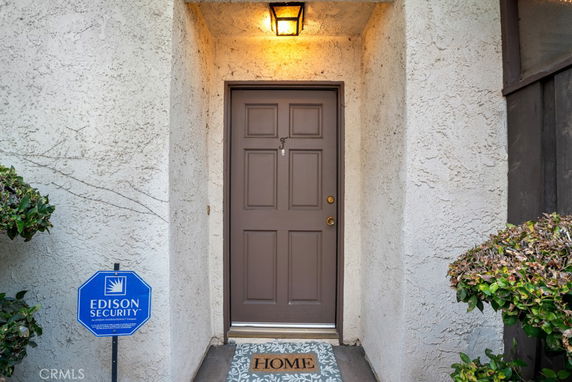 Front entrance of a house with a brown door and security sign.