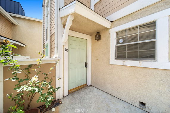Front view of a beige house entrance with a green door.