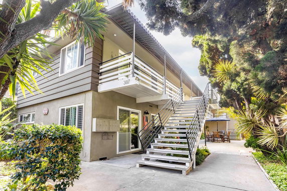 Front view of a two-story building with an external staircase and balconies.