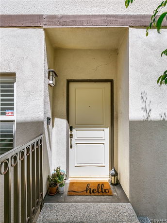 Front view of a house entrance with a white door and decorative lighting.