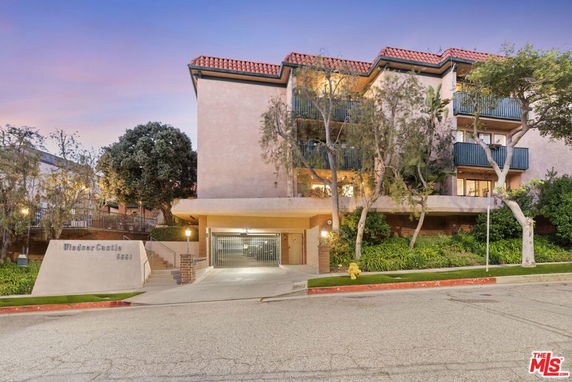 Front view of a multi-story apartment building with balconies.