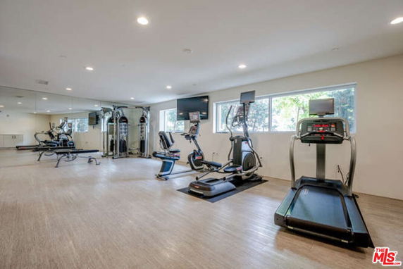Indoor gym area with exercise equipment and mirrored walls.