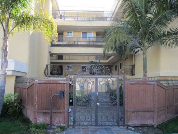Front view of a multi-story residential building with a gated entrance.