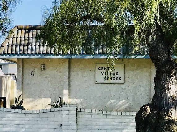 Front view of a building with a tiled roof and a sign reading 'Centa Villas Condos'.