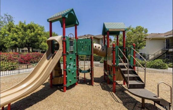 Outdoor playground with slides and climbing structures.