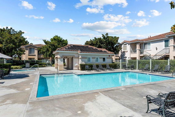 Outdoor swimming pool area with surrounding residential buildings.