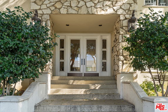 Front view of a house entrance with stone facade and glass door