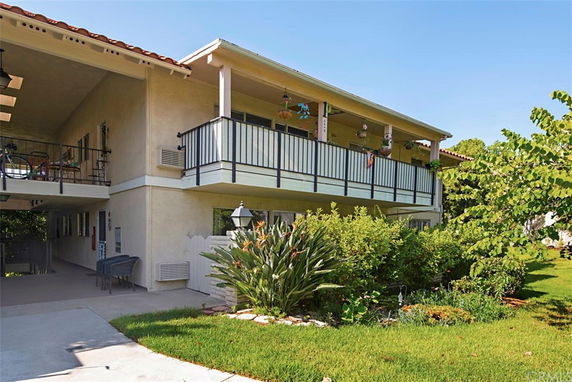 Front view of a two-story house with balconies and a garage entrance.