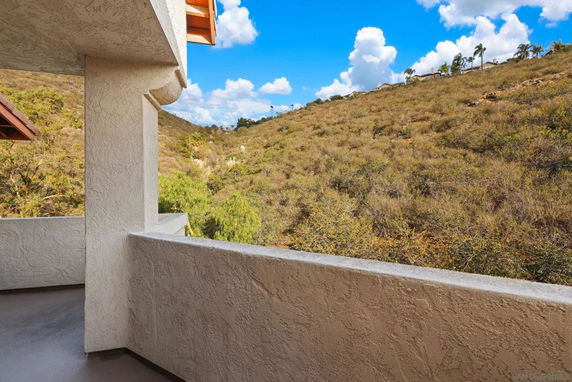 View of surrounding hilly landscape from a building balcony.