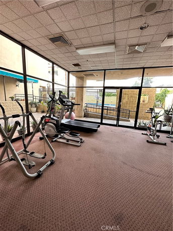 Indoor gym area with exercise equipment and large windows.