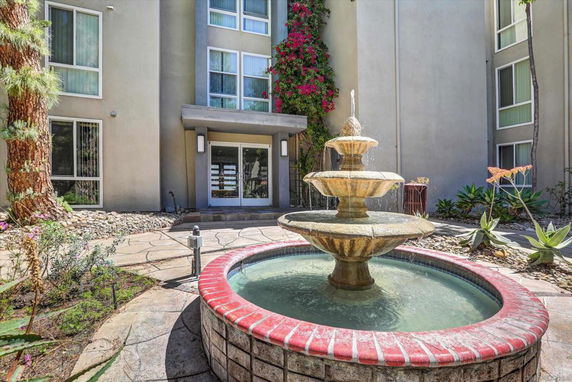 Front view of a building entrance with a decorative fountain.