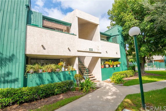 Front view of a building with green and white exterior and a central staircase.