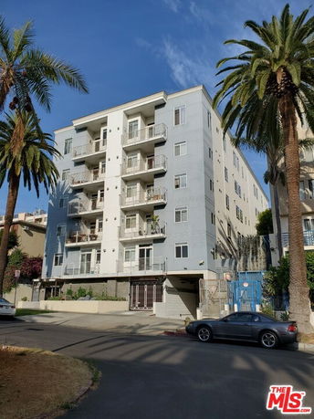Front view of a multi-story apartment building with balconies.
