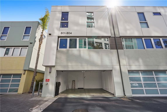 Front view of a modern multi-story building with garage openings.