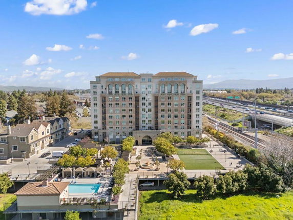 Front view of a multi-story residential building with adjacent amenities.