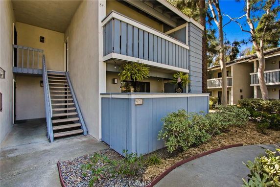 Front view of a multi-story residential building with balconies and exterior staircases.