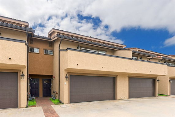 Front view of a two-story building with multiple garage doors and entryways.