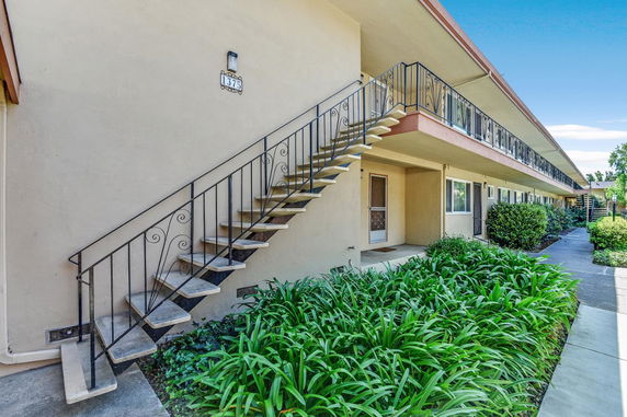 Front view of a two-story building with exterior staircases and railings.