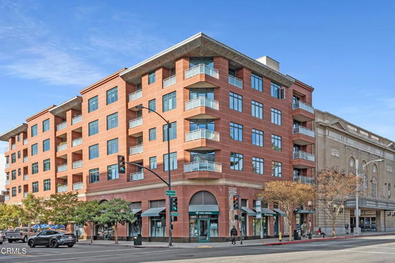 Front view of a multi-story brick building with large windows and balconies.