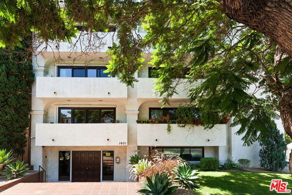 Front view of a multi-story building with balconies and a central entrance.
