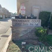 Signage for Promenade Court with building structures visible in the background.