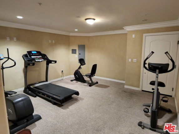 Indoor gym area with exercise equipment including treadmill and stationary bikes.
