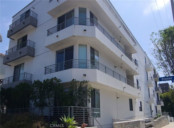 Front view of a modern multi-story apartment building with balconies.
