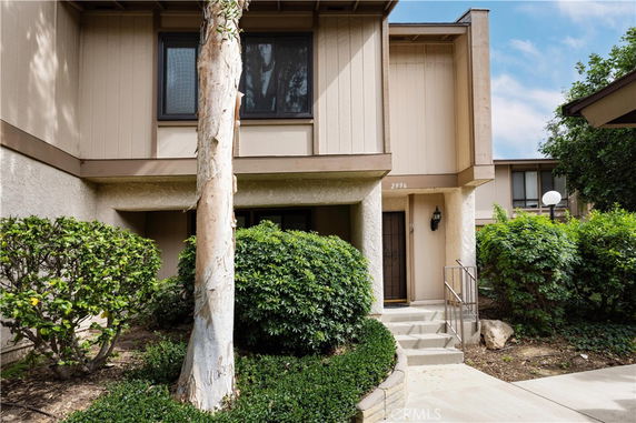 Front view of a two-story house with wooden paneling and a small porch.