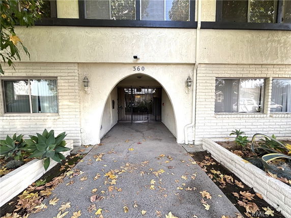Front view of a building with an arched entrance and two windows.