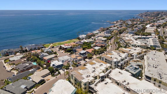 Panoramic view of coastal residential area with houses and oceanfront.