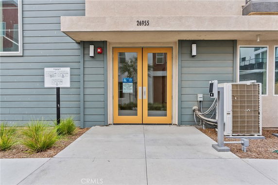 Front view of a building with yellow double doors and modern design.
