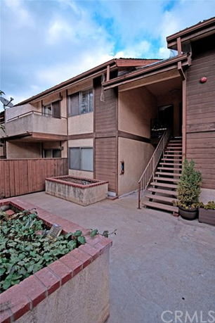 Front view of a two-story residential building with stairs leading to the second floor.
