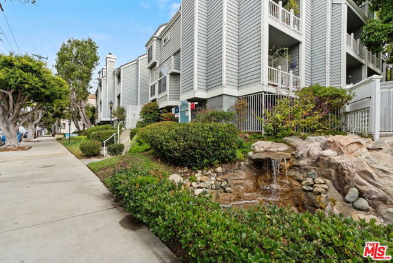 Front view of a multi-story building with balconies and grey siding.