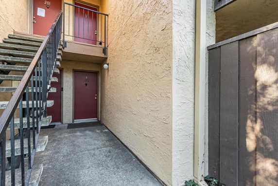Entrance view of a two-story apartment building with exterior stairs.