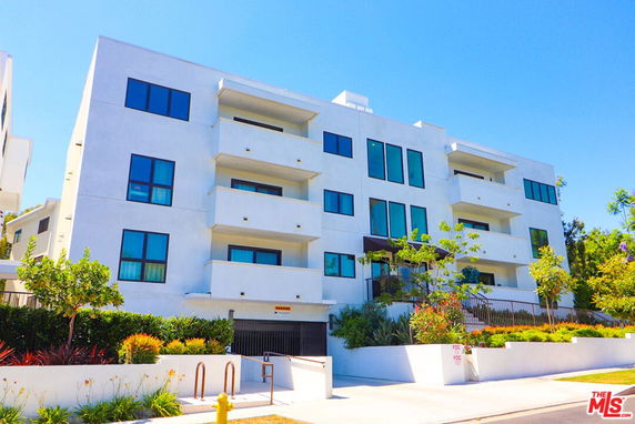 Front view of a multi-story apartment building with balconies.