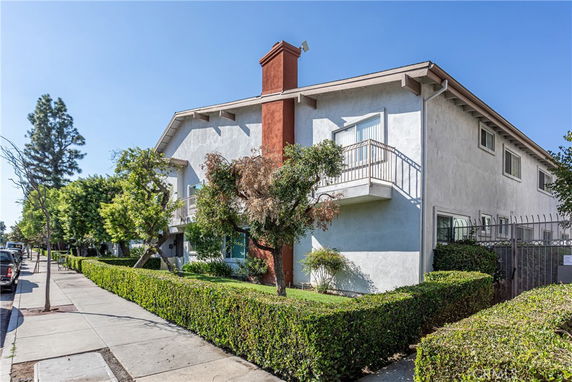 Front view of a two-story building with balconies and a chimney.