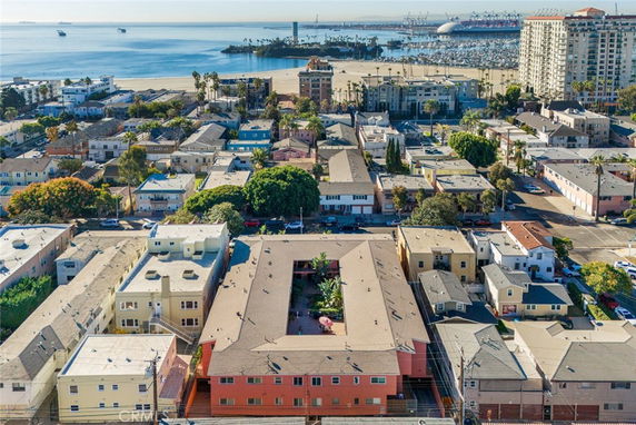 Aerial view of a residential area with multiple buildings and a waterfront in the background.
