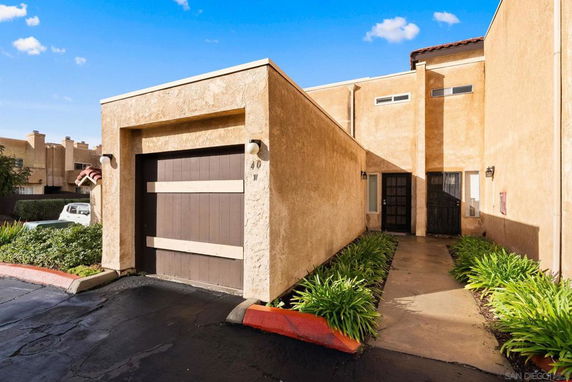 Front view of a two-story house with a garage and paved walkway.