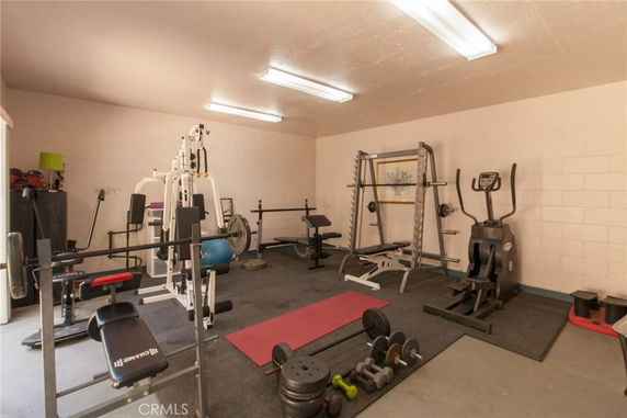 Indoor gym area with various exercise equipment including weights and machines.