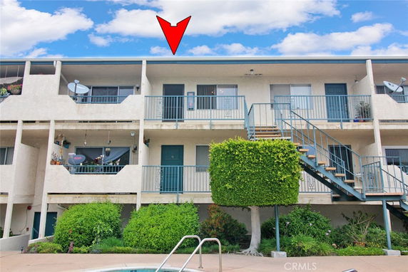 Front view of a two-story apartment building with exterior staircases and balconies.