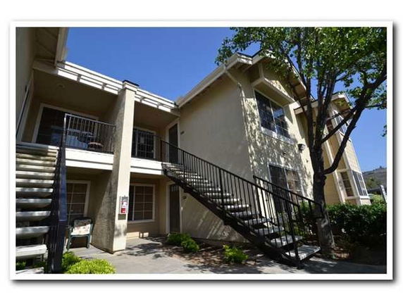 Front view of a two-story apartment building with exterior staircases.
