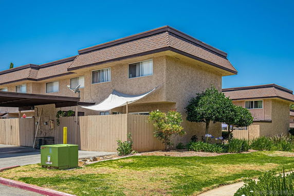 Front view of a two-story building with a flat roof design and a fenced yard.