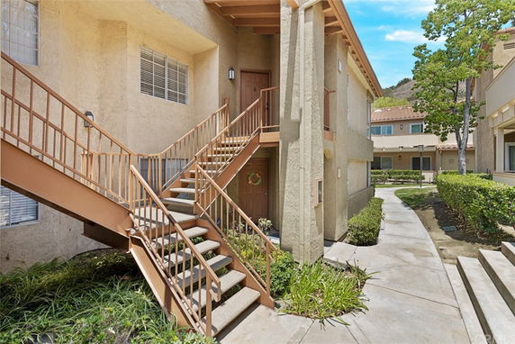 Front view of a two-story apartment building with external staircase.
