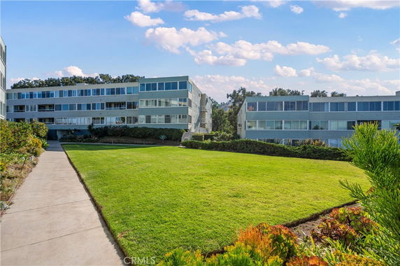 Front view of a multi-story residential building complex with large windows.