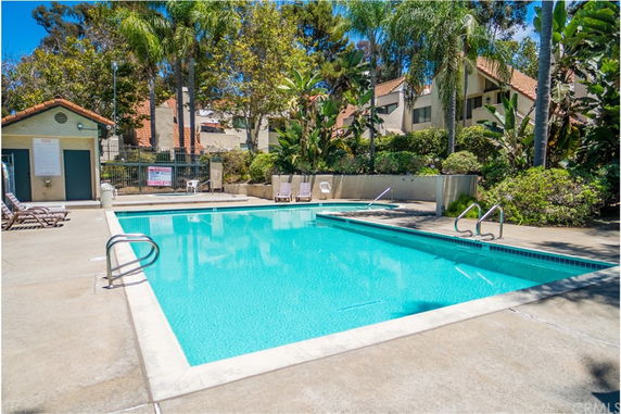 Outdoor swimming pool area with surrounding deck and lounge chairs.