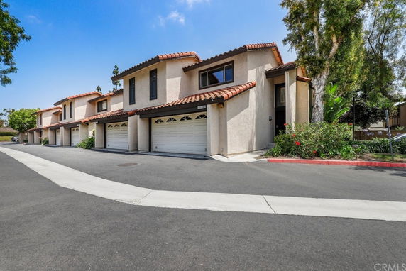 Front view of a row of two-story townhouses with garages.