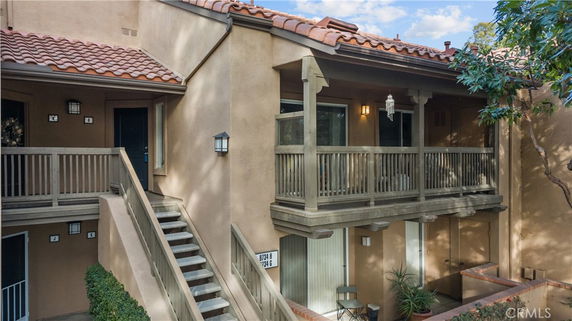 Front view of a multi-level building with balconies and a staircase leading to the upper floor.