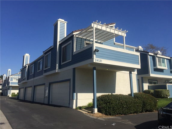 Front view of a multi-story building with garages on the ground floor.