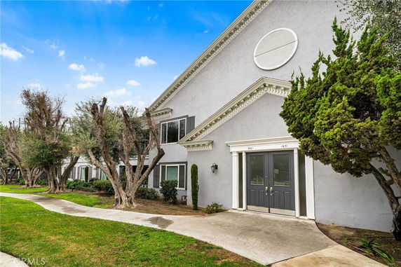 Front view of a two-story building with decorative trims and double doors.